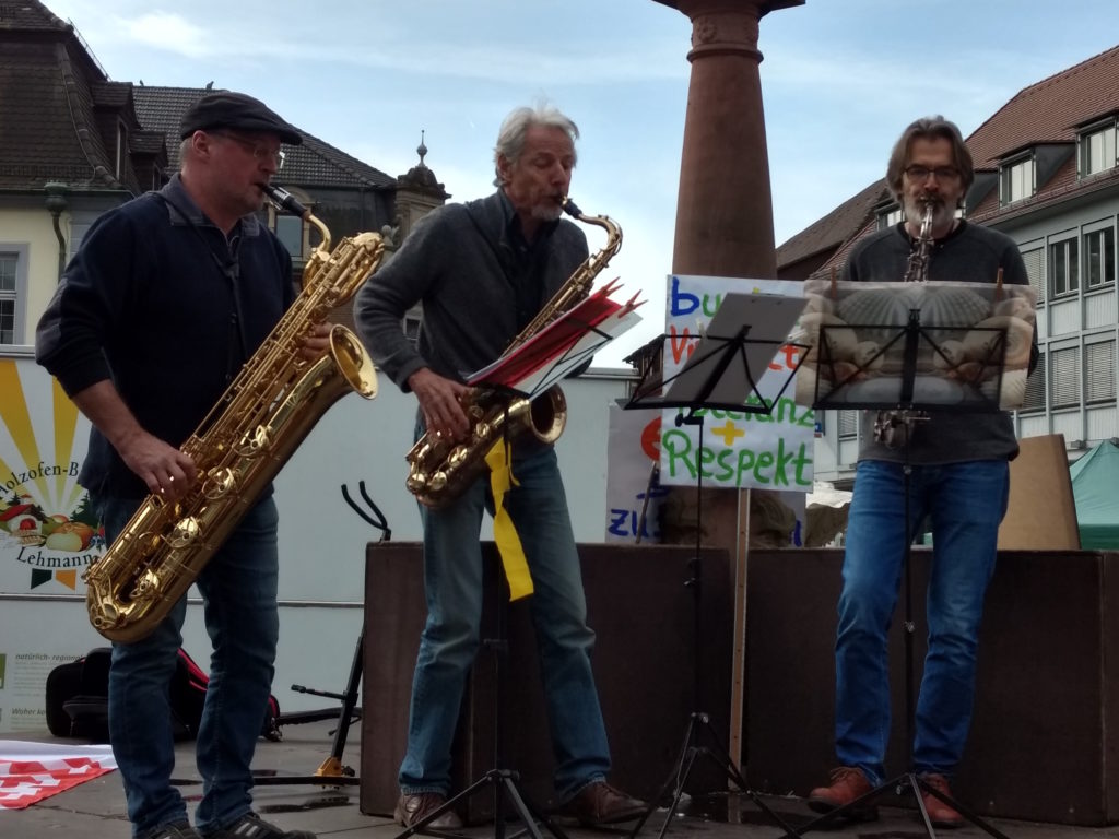 Drei Saxophon spielende Männer auf dem Brunnen des Emmendinger Marktplatzes.